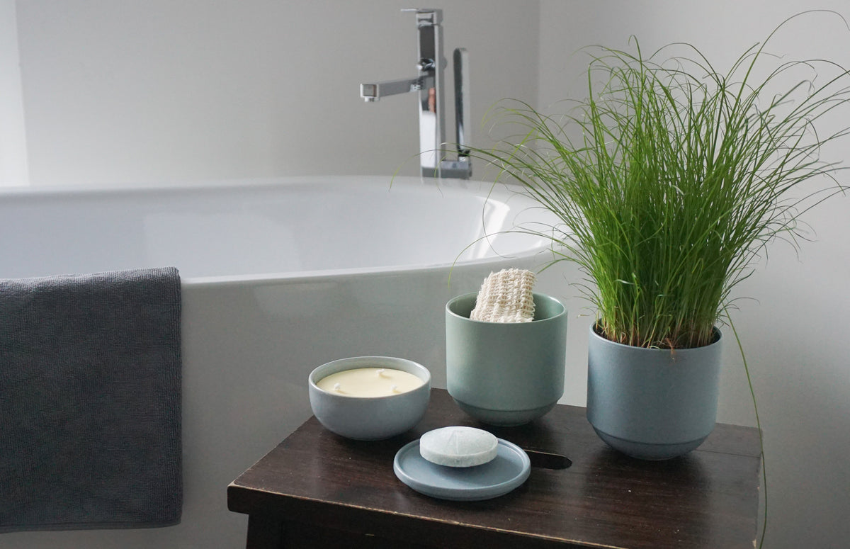 Badewanne mit Keramikgefäßen für Seife, Kerze und Waschlappen