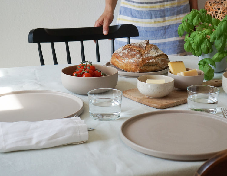 Frühstückstisch mit Keramiktellern und Keramikschalen
